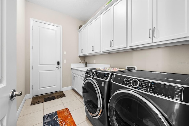 washroom featuring light tile patterned floors, sink, independent washer and dryer, and cabinets