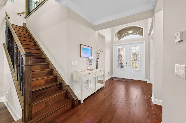 foyer featuring dark hardwood / wood-style flooring, ornamental molding, and french doors