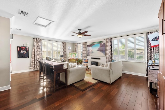 living room featuring a textured ceiling, ceiling fan, crown molding, and dark hardwood / wood-style floors