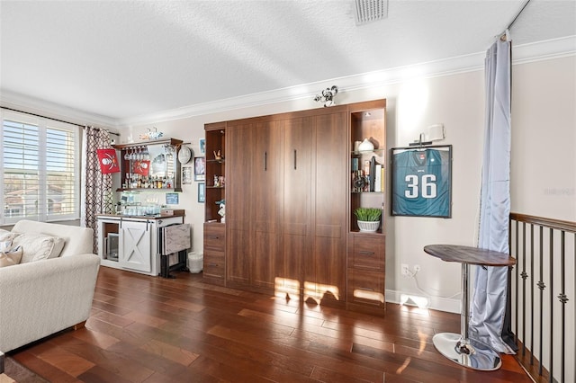 interior space featuring dark wood-type flooring, a textured ceiling, and crown molding