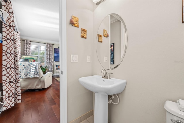 bathroom featuring toilet, sink, crown molding, and hardwood / wood-style flooring