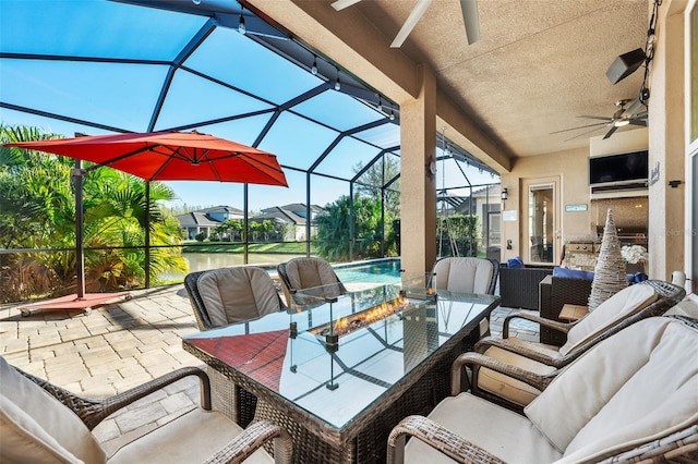 view of patio with ceiling fan and glass enclosure