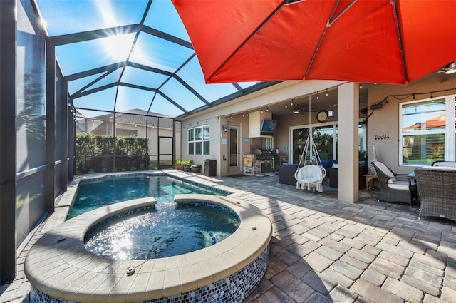 view of swimming pool featuring a lanai, exterior kitchen, a patio, and an in ground hot tub