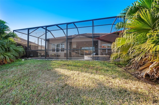 back of property with a lanai and a lawn