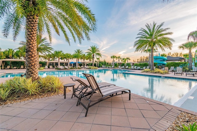 pool at dusk featuring a patio area