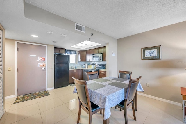 tiled dining space featuring a textured ceiling