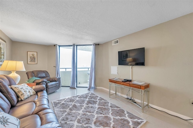 living room with a textured ceiling and a wall of windows