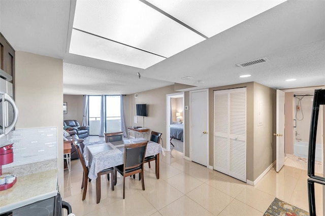 tiled dining space with a textured ceiling