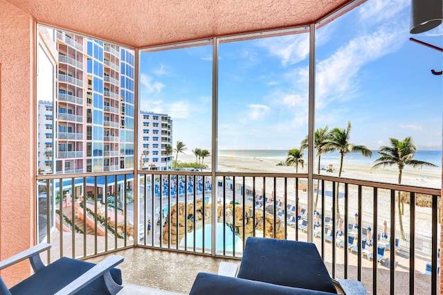 balcony featuring a beach view and a water view