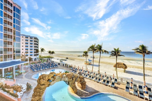 view of pool with a water view and a beach view