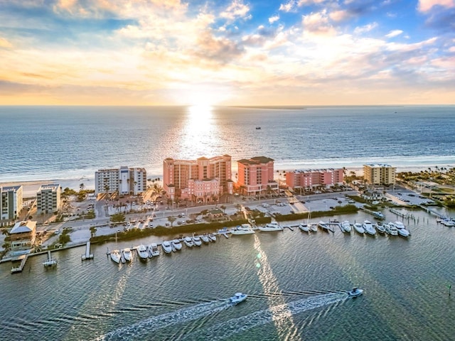 aerial view at dusk featuring a water view