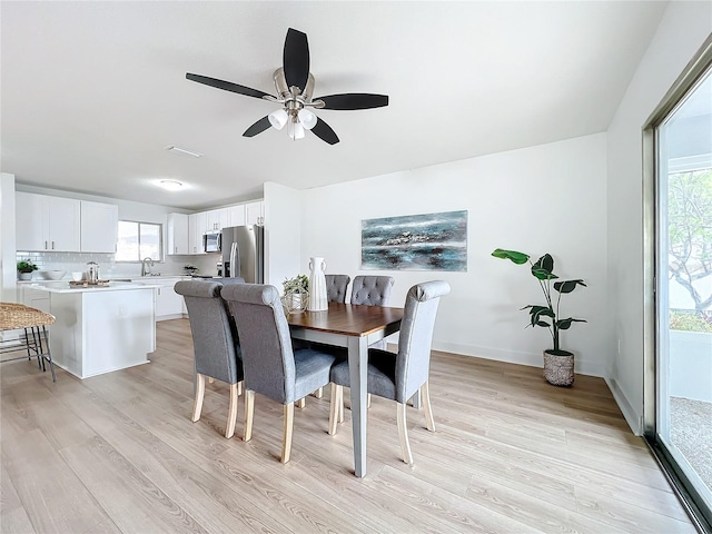 dining space featuring ceiling fan and light wood-type flooring