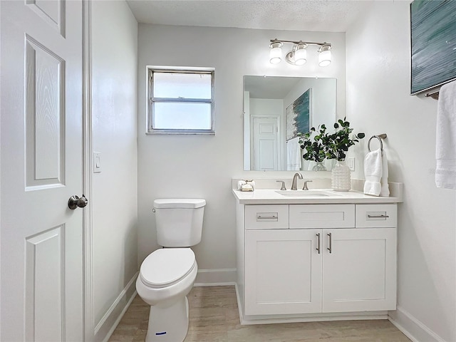 bathroom featuring hardwood / wood-style floors, vanity, a textured ceiling, and toilet