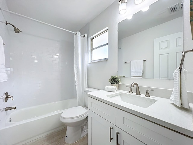 full bathroom with shower / tub combo, vanity, hardwood / wood-style flooring, and toilet