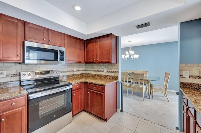 kitchen featuring hanging light fixtures, a chandelier, stone countertops, light tile patterned floors, and appliances with stainless steel finishes