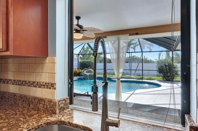 view of swimming pool with pool water feature and ceiling fan