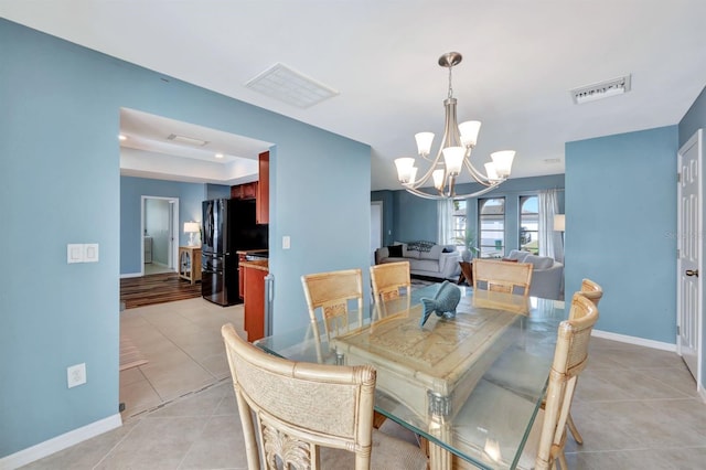 dining room featuring light tile patterned floors and an inviting chandelier