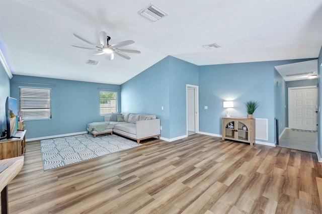 living room featuring vaulted ceiling, light hardwood / wood-style flooring, and ceiling fan