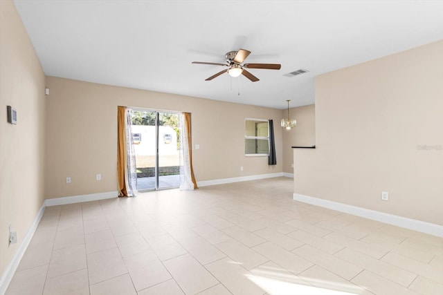 tiled empty room featuring ceiling fan with notable chandelier