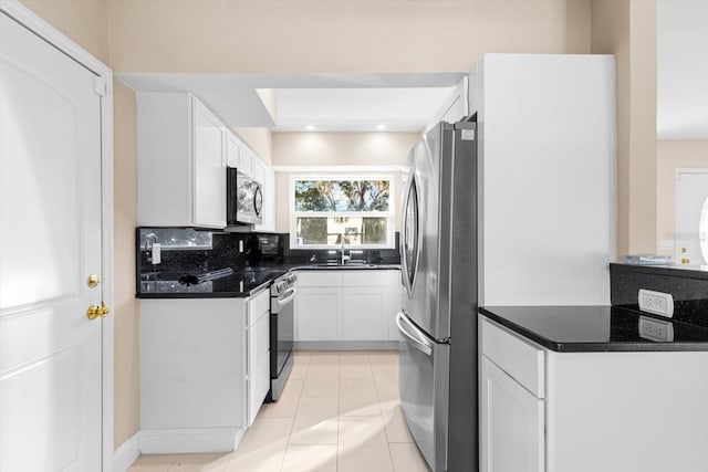 kitchen with tasteful backsplash, stainless steel appliances, sink, light tile patterned floors, and white cabinets