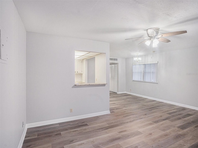 unfurnished room with ceiling fan, a textured ceiling, and hardwood / wood-style flooring