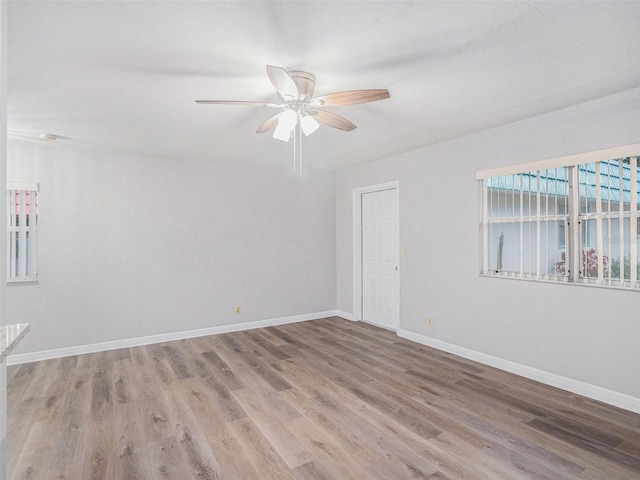 spare room with ceiling fan and light wood-type flooring