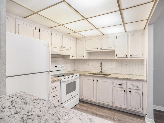 kitchen with decorative backsplash, white appliances, sink, and light hardwood / wood-style flooring