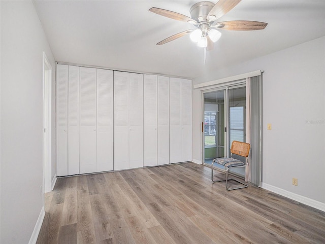 unfurnished bedroom with ceiling fan, access to exterior, light wood-type flooring, and a closet