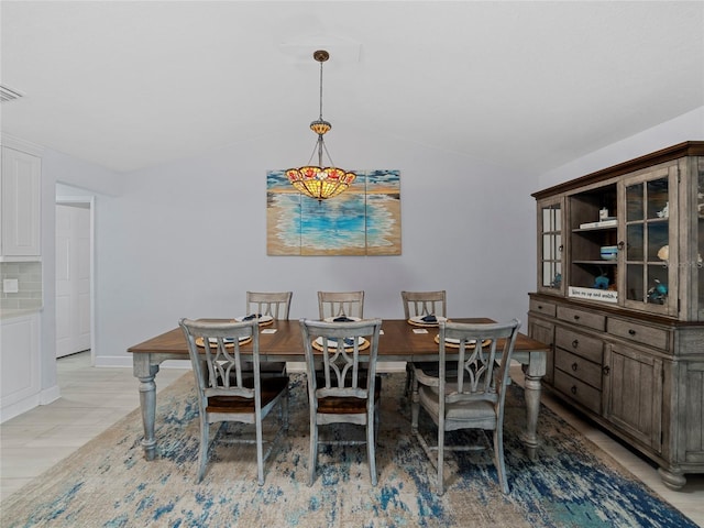 dining space featuring vaulted ceiling