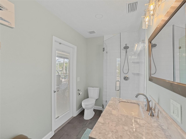 bathroom with vanity, toilet, and a shower with shower door