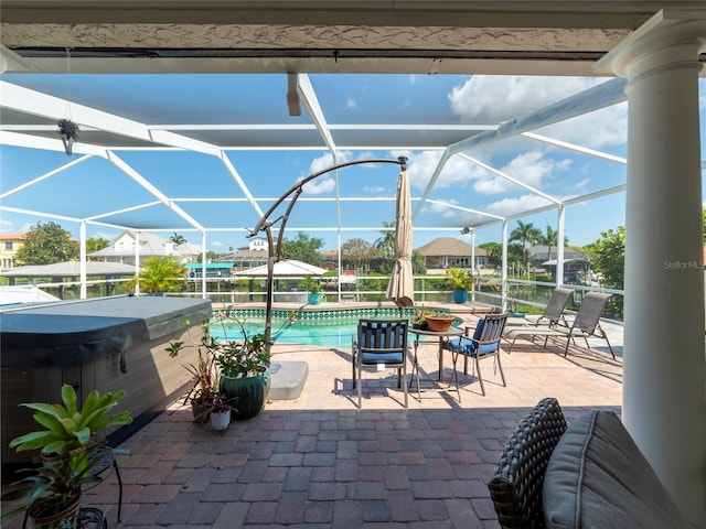 view of patio featuring glass enclosure and a pool with hot tub