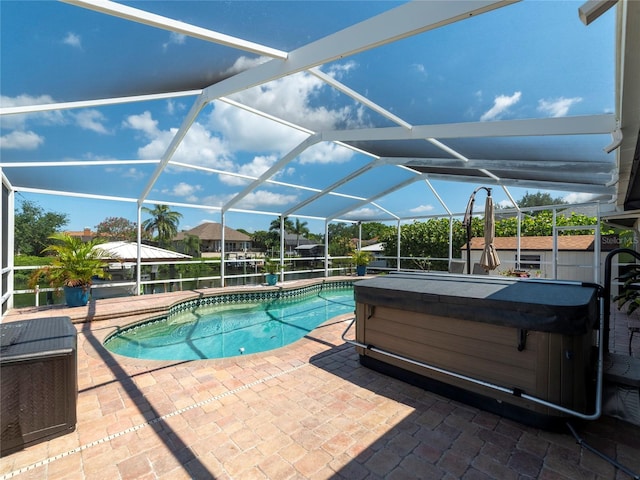 view of swimming pool featuring a patio, a hot tub, and a lanai