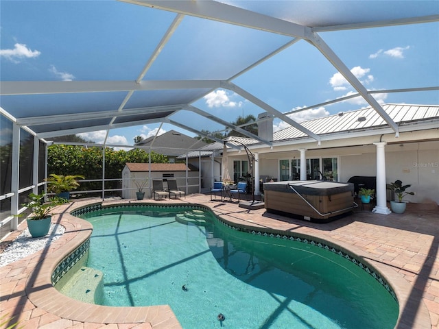 view of pool featuring a hot tub, a storage unit, a lanai, and a patio area