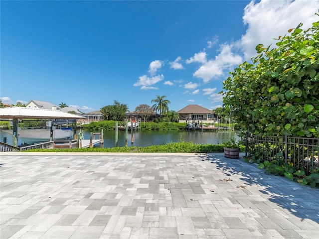 view of patio featuring a water view and a dock