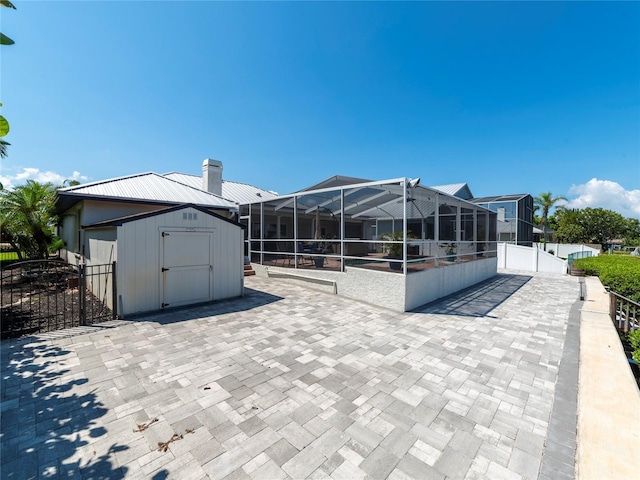 view of patio / terrace with a lanai and a storage shed