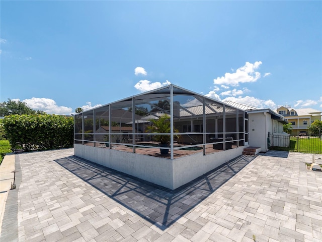 view of patio with glass enclosure and a pool