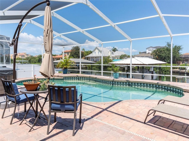 view of swimming pool featuring a patio area and glass enclosure