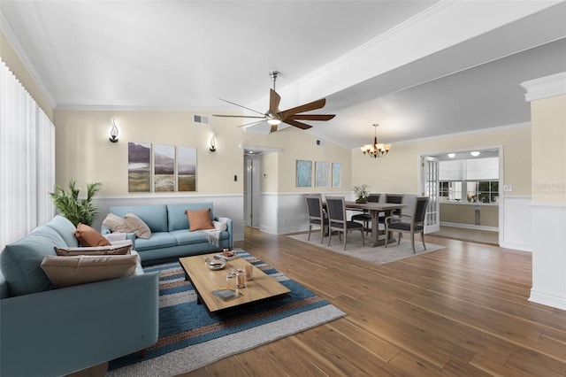 living room featuring hardwood / wood-style floors, ceiling fan with notable chandelier, crown molding, and vaulted ceiling