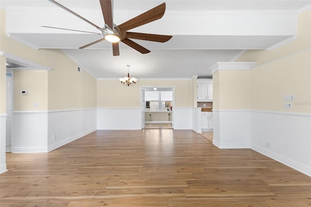 unfurnished room with light hardwood / wood-style floors, ceiling fan with notable chandelier, and ornamental molding