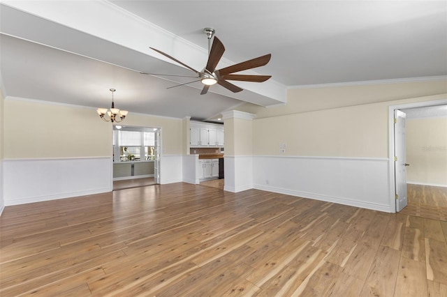 unfurnished living room featuring crown molding, ceiling fan with notable chandelier, lofted ceiling, and light wood-type flooring