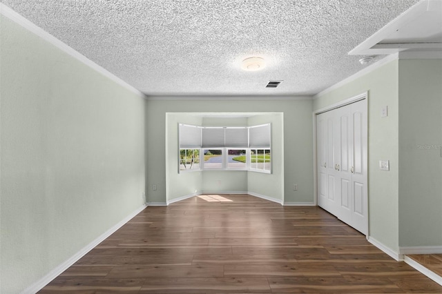 empty room with dark hardwood / wood-style flooring and ornamental molding