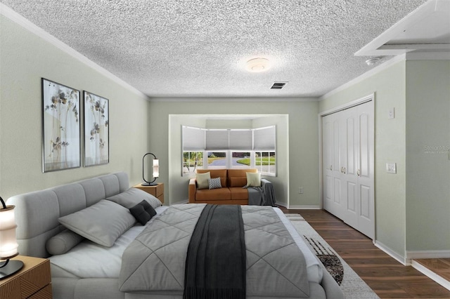 bedroom featuring dark hardwood / wood-style flooring, crown molding, and a closet