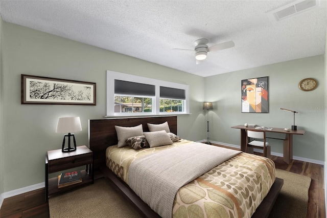 bedroom featuring hardwood / wood-style floors, ceiling fan, and a textured ceiling