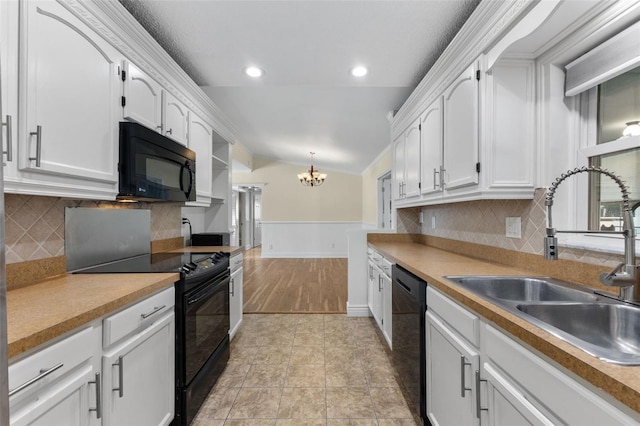 kitchen with sink, black appliances, decorative light fixtures, a notable chandelier, and white cabinetry