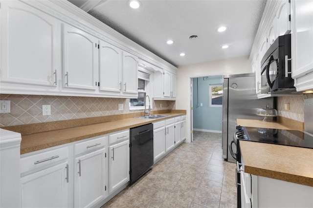 kitchen featuring black appliances, backsplash, white cabinets, and sink