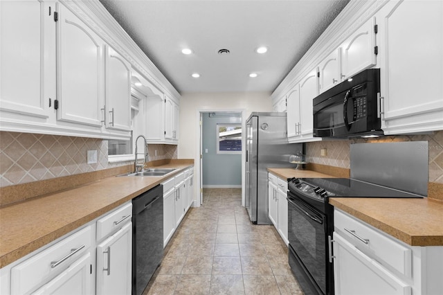 kitchen featuring black appliances, decorative backsplash, white cabinets, and sink