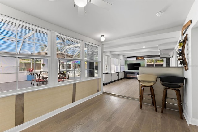 kitchen featuring hardwood / wood-style flooring, a kitchen breakfast bar, and ceiling fan