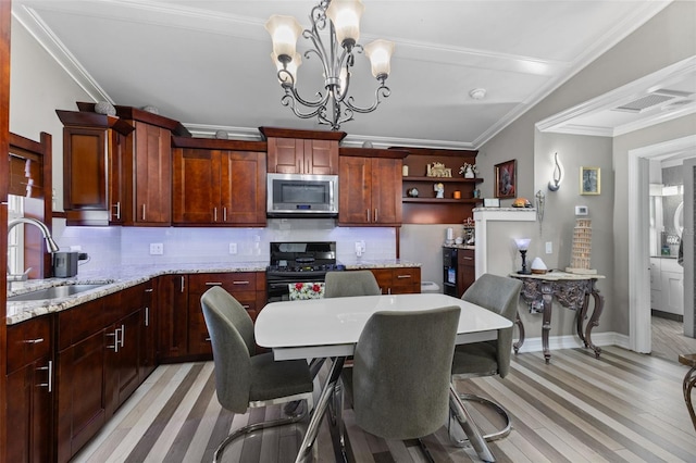 dining space with light hardwood / wood-style floors, crown molding, a notable chandelier, and sink