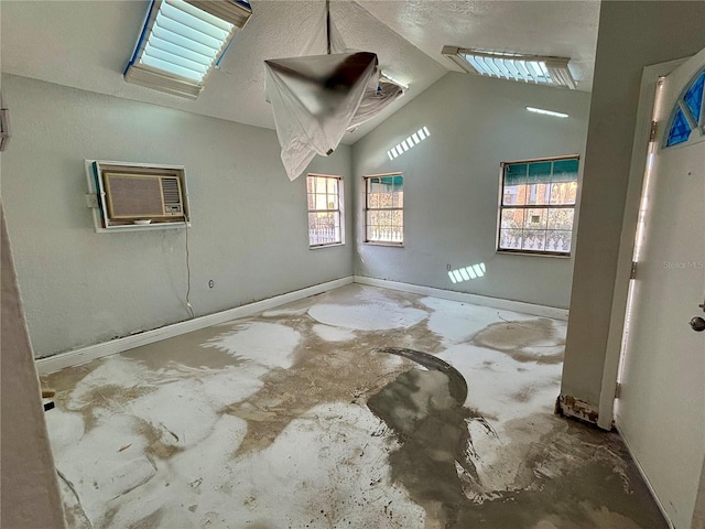 empty room featuring a wall mounted air conditioner and lofted ceiling