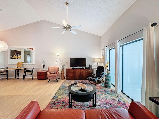 living room with hardwood / wood-style flooring, ceiling fan, and lofted ceiling